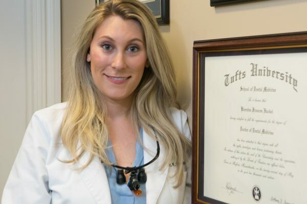 Dr. Kiersten Huckel beside her Tufts University School of Dental Medicine diploma