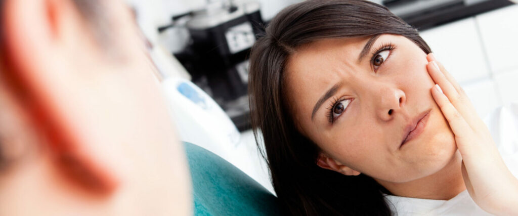 Woman holding her jaw in discomfort